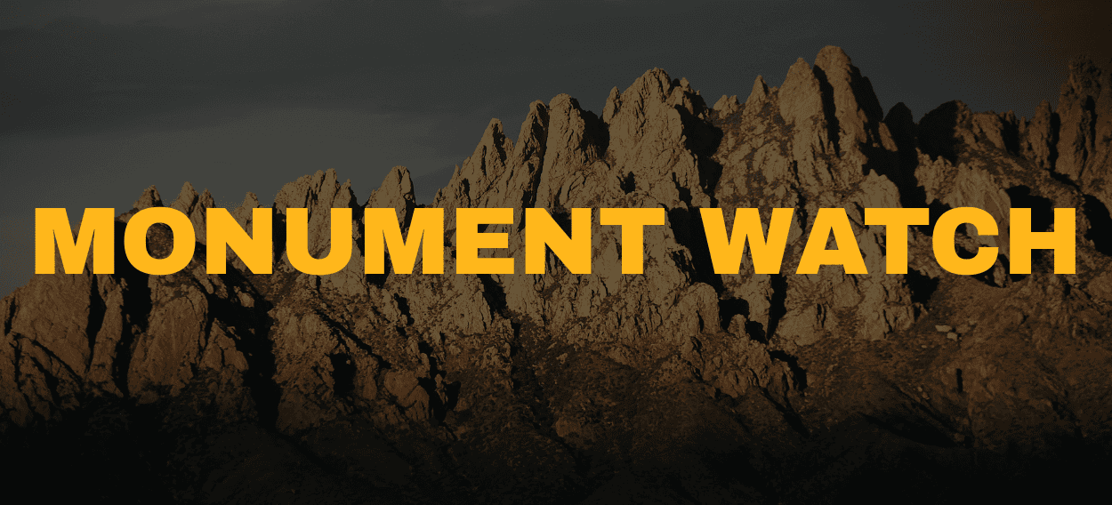 The organ mountains rise behind Monument Watch text
